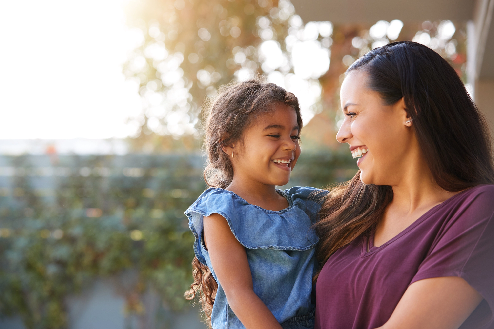 mother holding her smiling daughter
