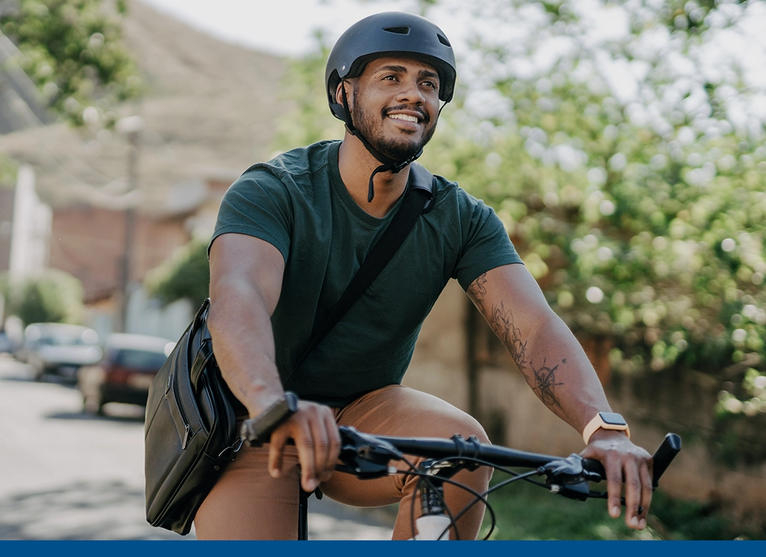 young, health man riding his bike to work with a helmet on his head