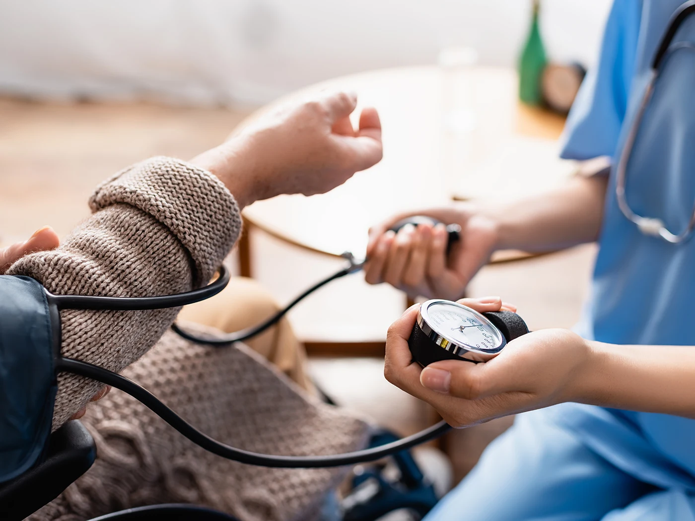 A nurse checks the blood pressure of a patient