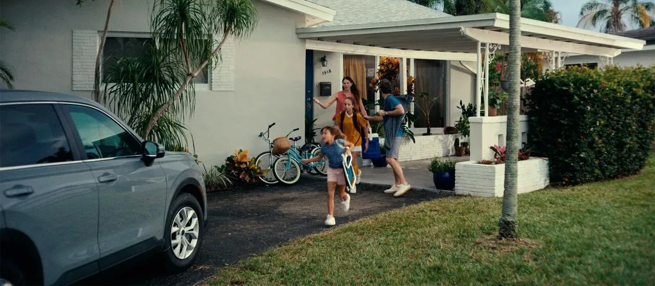 family heading to their car leaving their home on the way to the beach