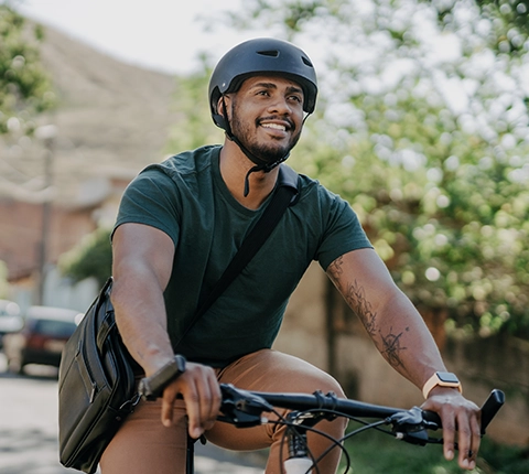 young, health man riding his bike to work with a helmet on his head