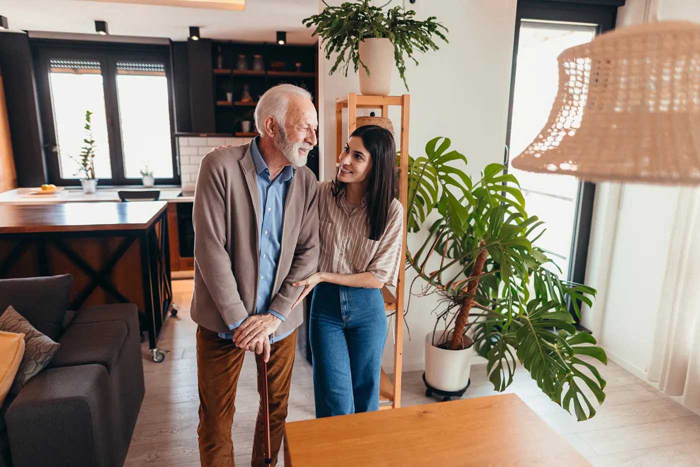 woman caregiver supporting an older gentleman while walking