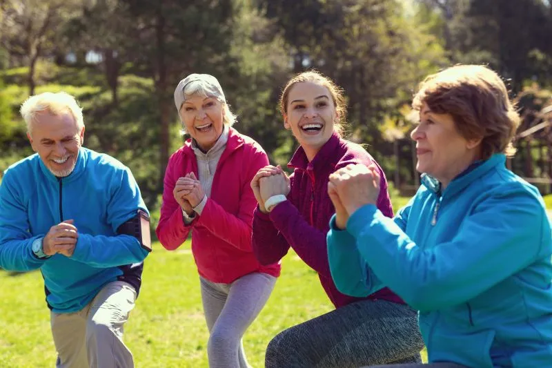 Older adults working out in the park with a trainer