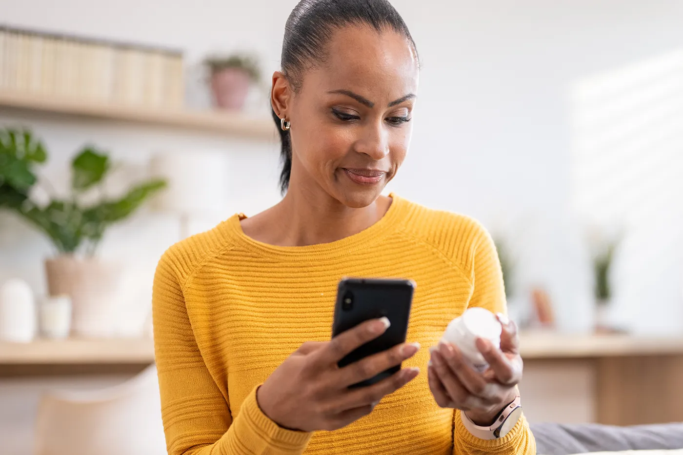 Woman using MyPrime on phone to reorder prescription