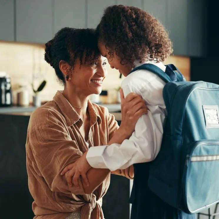 mother preparing young daughter for school