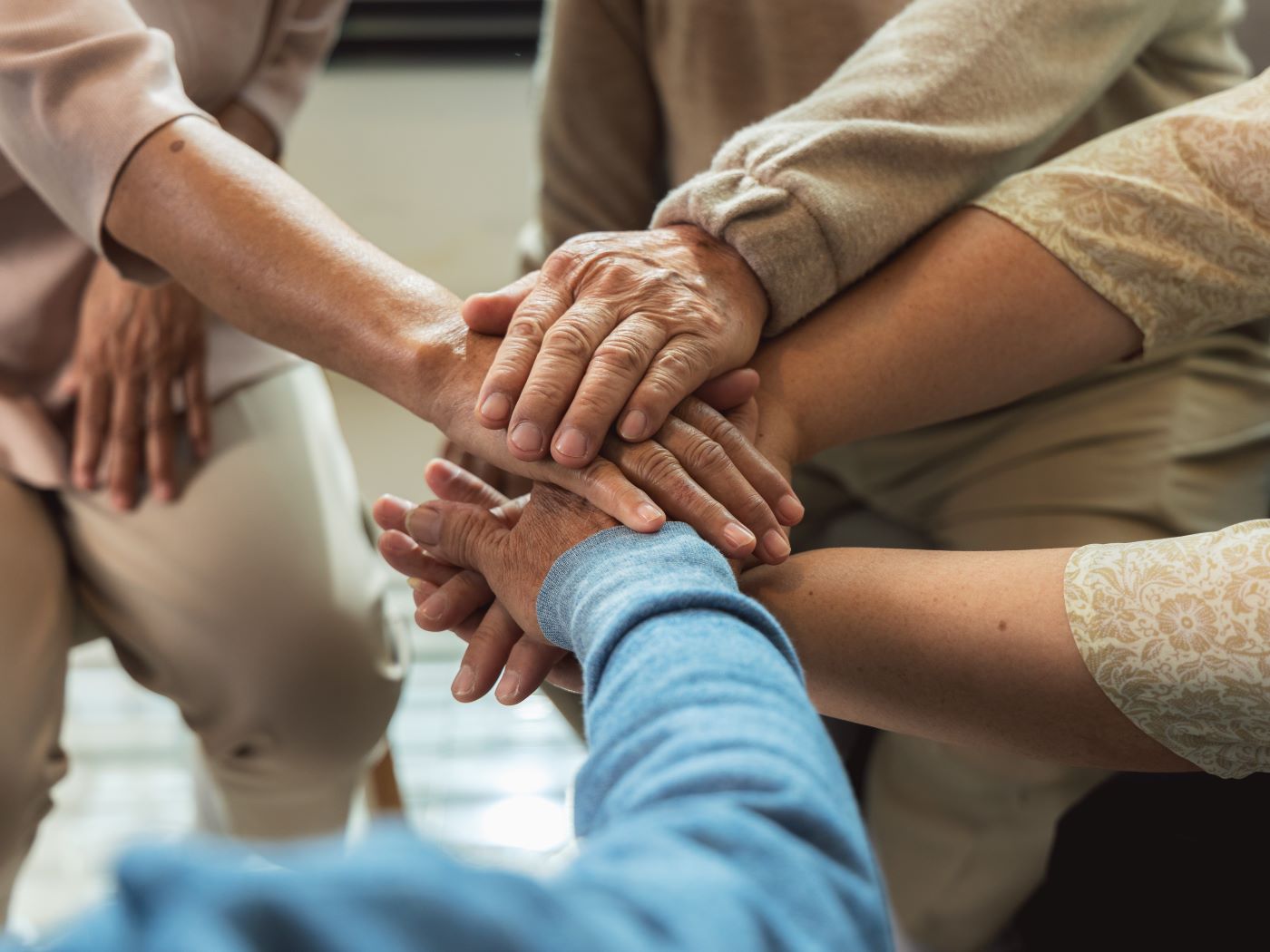 Group of people placing hands together