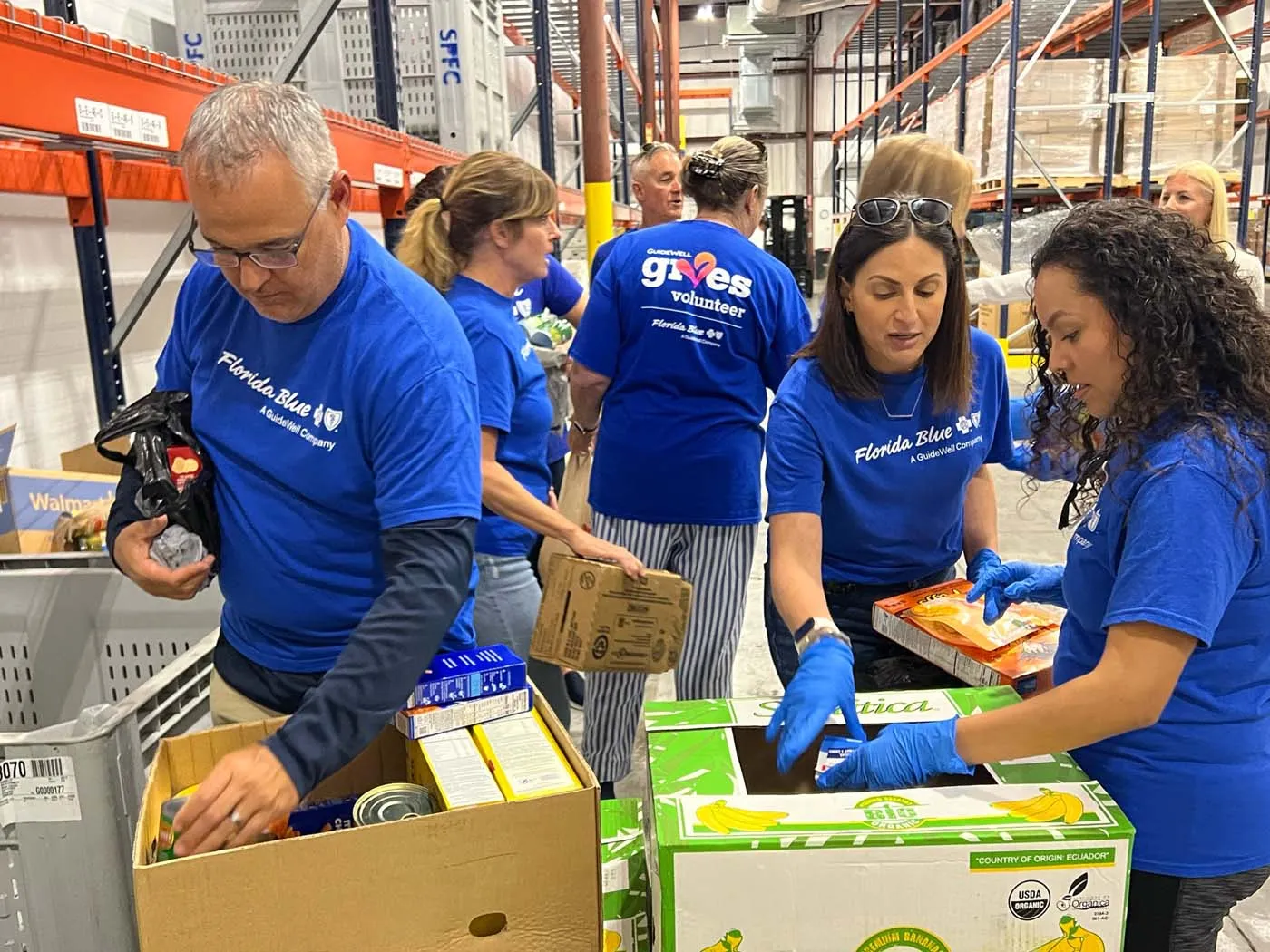 Voluntarios de Florida Blue se unen para clasificar y empacar alimentos en un evento de recolección de alimentos para la comunidad.