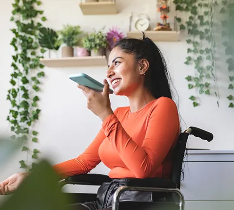 Mujer en silla de ruedas hablando por teléfono con un agente dedicado sobre la inscripción en un plan de salud de Florida Blue para 2026