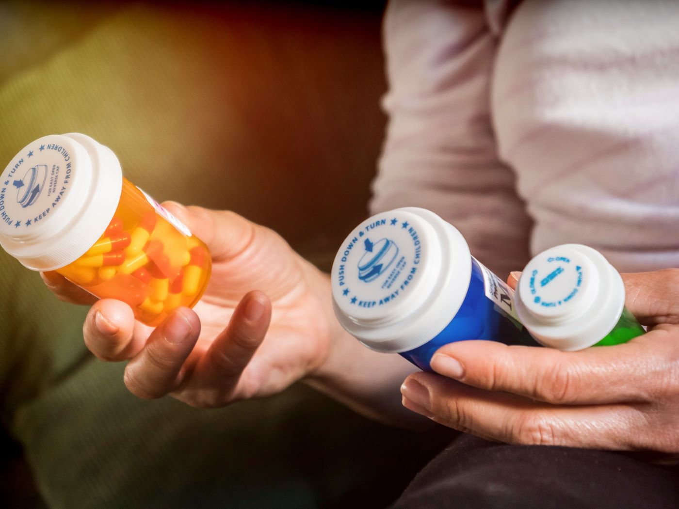 A patient looks at her pill bottles.