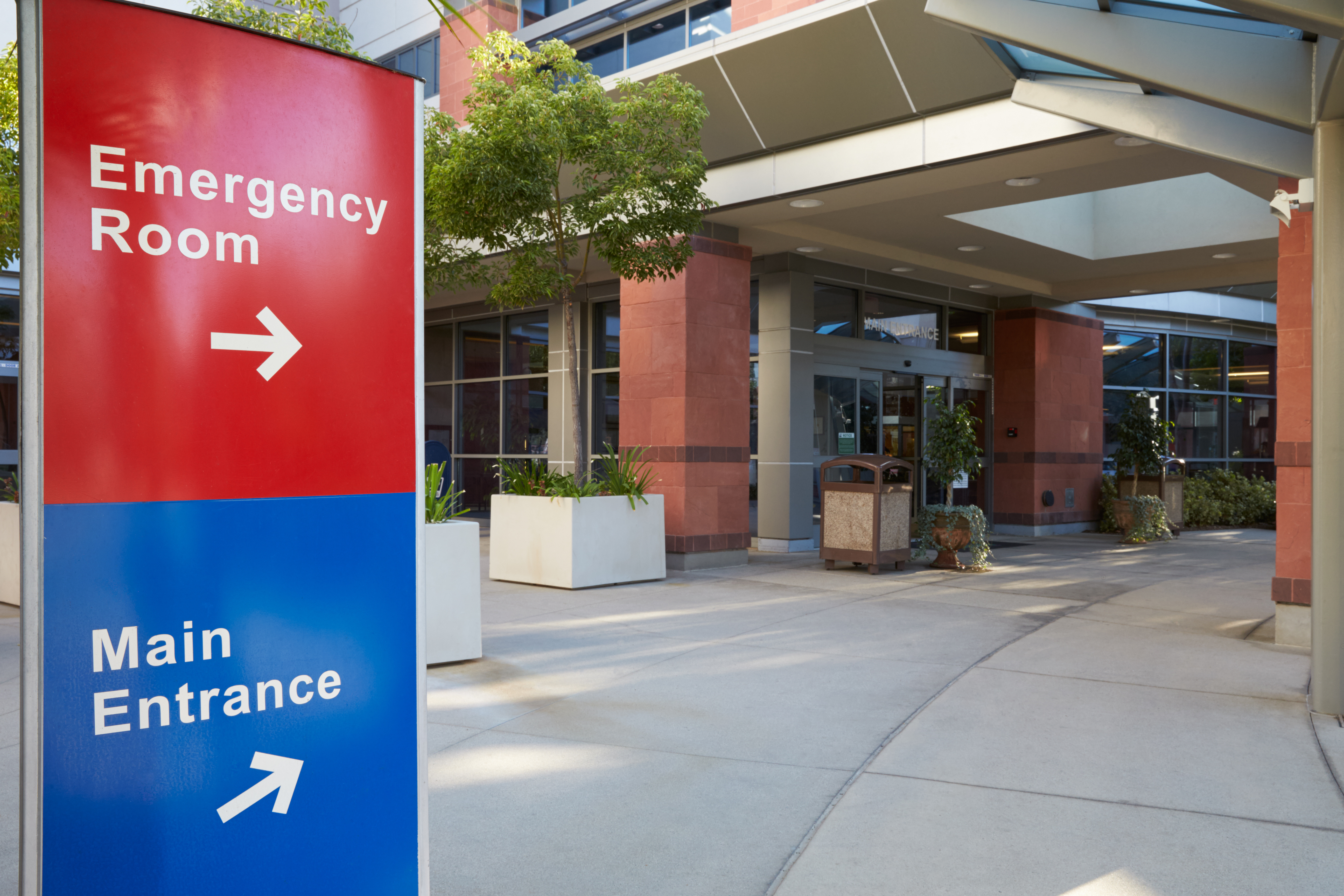 Main entrance of modern hospital building with signs
