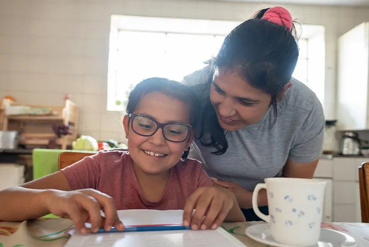 Madre ayudando a su joven hija con la tarea