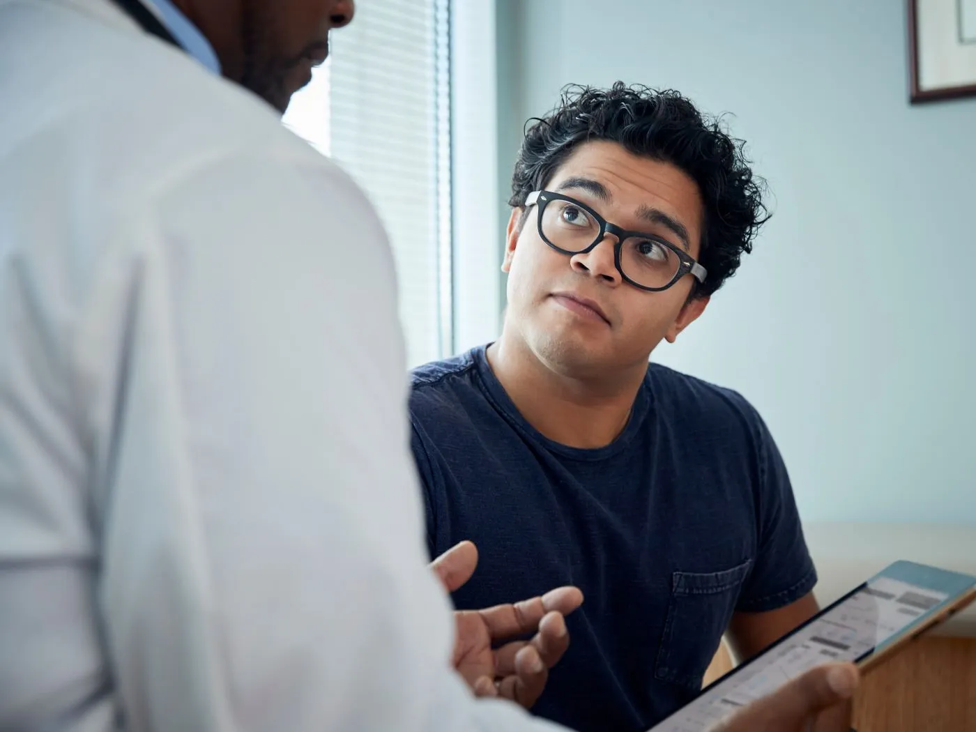 Un paciente adulto escucha a su médico.