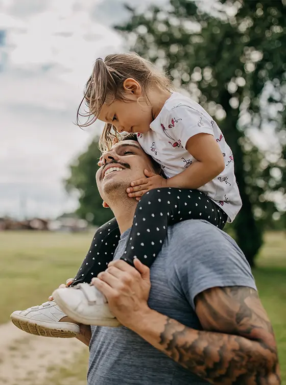 young dad with small daughter on his shoulders