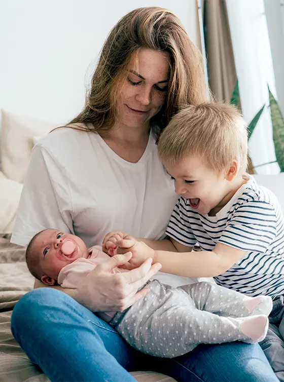 young mother with toddler boy and newborn baby