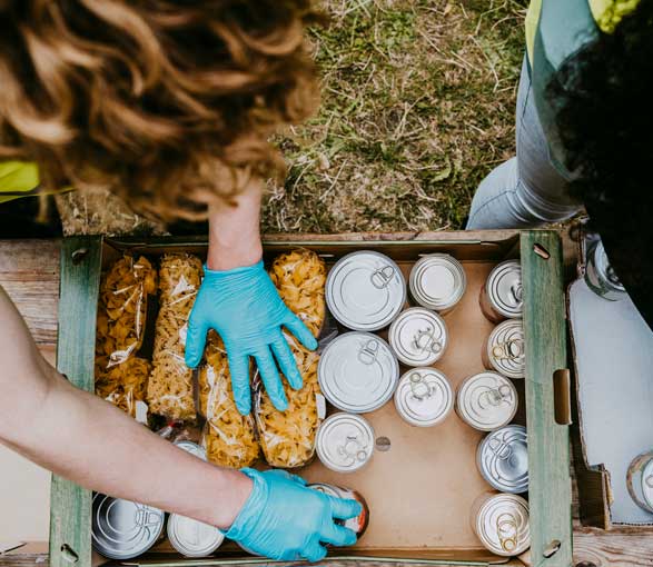 Women packing canned goods into crate