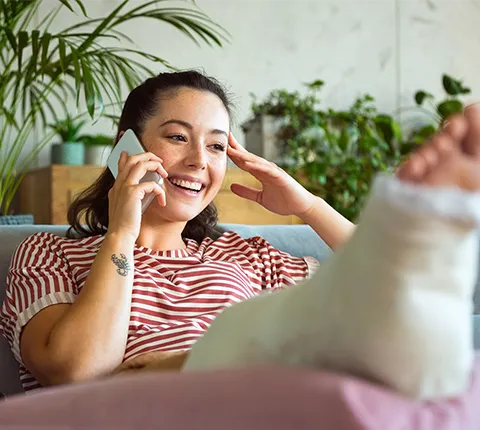 woman in a leg cast talking to a Florida blue agent on the phone
