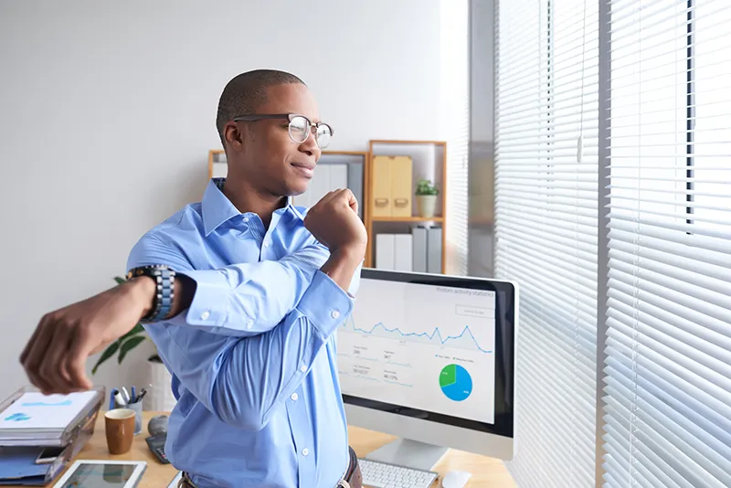 man in office stretching to reach whole-person health