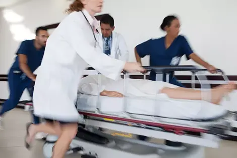 Doctors rushing a patient through the hospital hallway